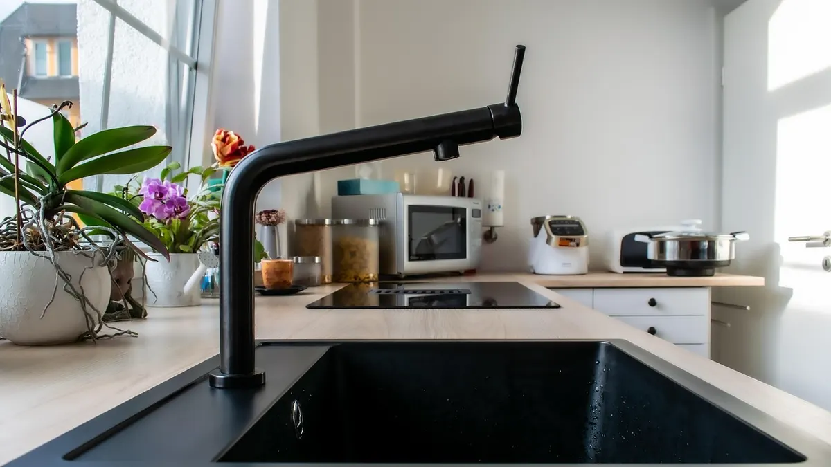 Pia de cozinha preta com torneira alta moderna
